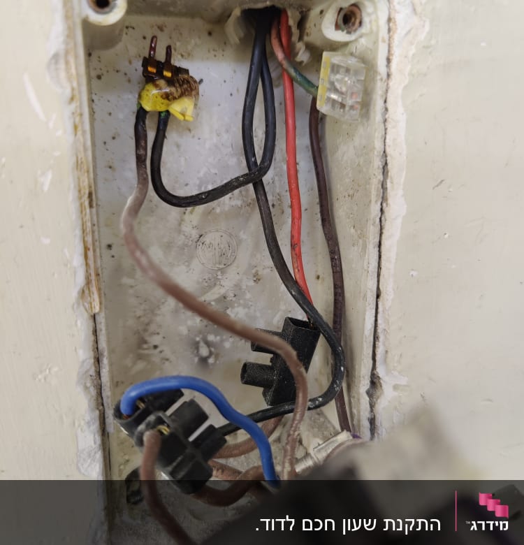 חוטי חשמל צבעוניים בקופסת חיבורים חשמלית